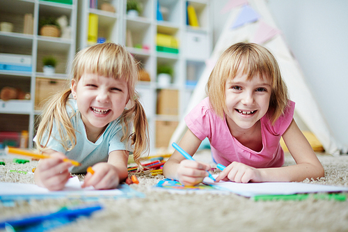 Cheerful little girls  while drawing