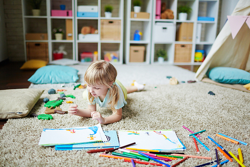 Cute girl looking at pictures on the floor