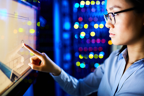 Modern engineer touching screen of supercomputer