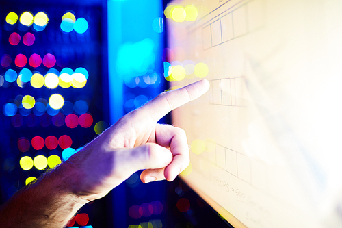 Male hand touching a touchscreen in datacenter