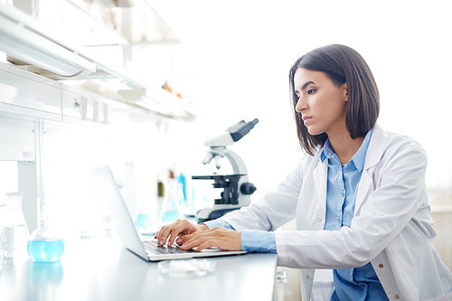 Female scientist browsing in the net during investigation or research