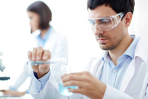 Researcher mixing two fluid samples with chemicals to make scientific discovery