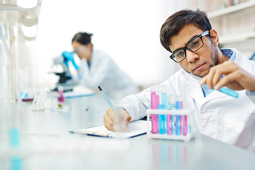 Serious scientist working with liquids in laboratory