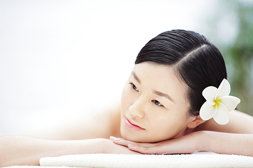 Asian woman relaxing in spa salon