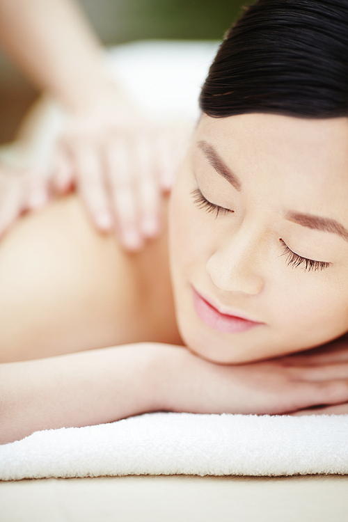 Calm female during luxurious procedure of massage