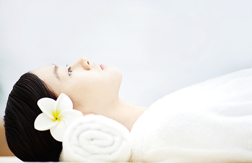 Woman in spa salon lying on massage desk