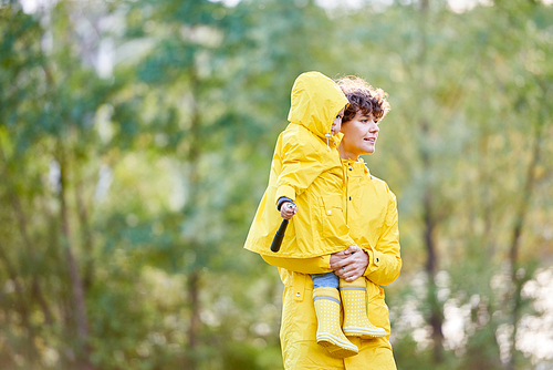 Mother walking with her daughter in raincoats