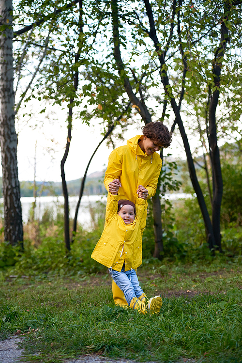 Happy woman and her child playing on green grass
