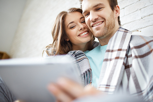 Amorous couple looking at touchpad at leisure