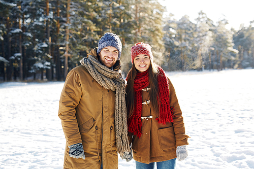 Two young people in winterwear spending time in park