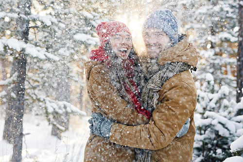 Laughing couple walking in snowfall