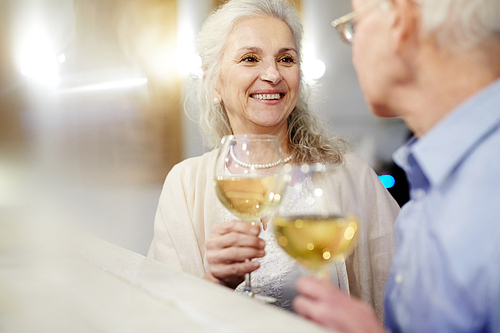Senior couple toasting with wine or champagne in restaurant