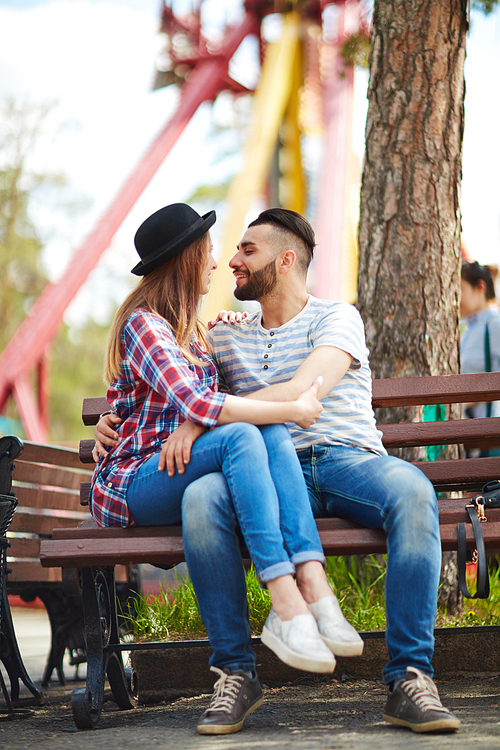 Young couple sitting on bench and embracing