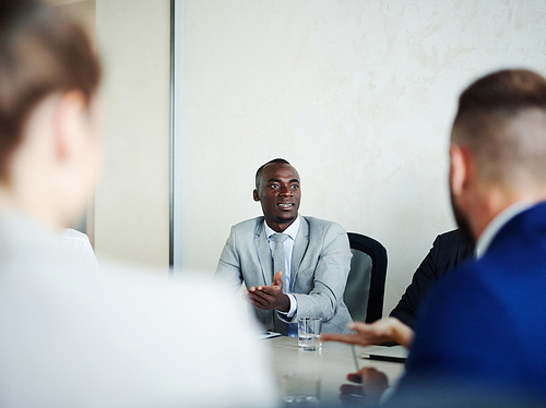 Business expert consulting young colleagues at briefing