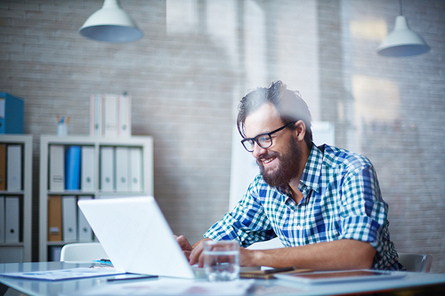 Young man working in office alone and smiling