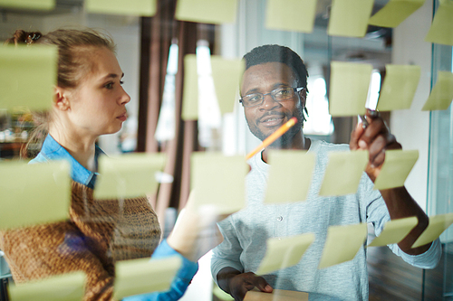 Multi-ethnic colleagues reading notes in office