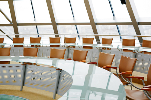 Modern conference hall with round table and chairs around it