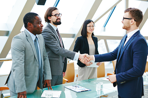 Two happy business partners handshaking after making agreement