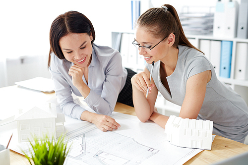 Two pretty architects looking at sketch of new construction