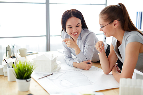 Women brainstorming while looking at sketch of construction