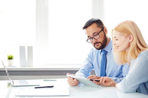 Two office workers discussing data at workplace