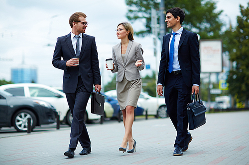 Young business people walking together along the street