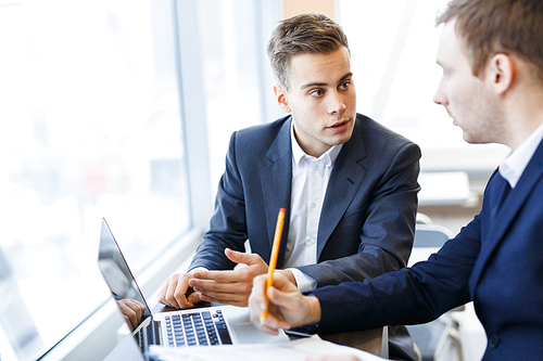 Young specialist explaining his view point to elder colleague