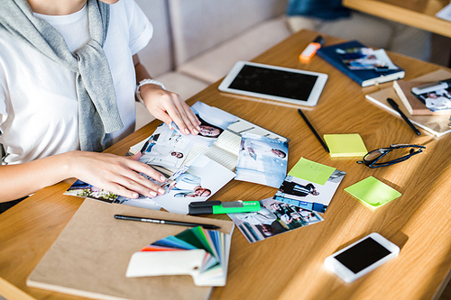 Female designer working with photos by desk