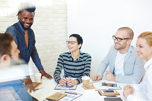 Happy young employees discussing new plans and ideas