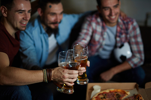 Men toasting with glasses of beer for victory of soccer team