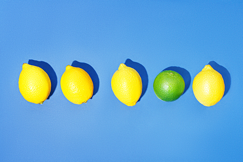 Row of lemons with one lime