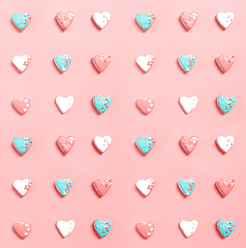 Pink background with rows of homemade heart-shaped cookies