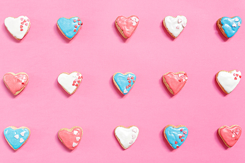 Pink background with rows of homemade heart-shaped pastries