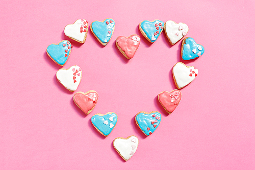 Heart cookies decorated with glaze isolated on pink background