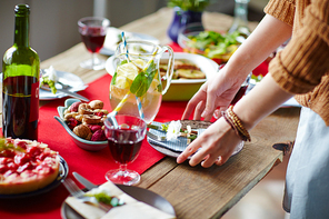 Woman putting plates on table for dinner