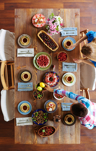 Girls putting festive food on wooden table