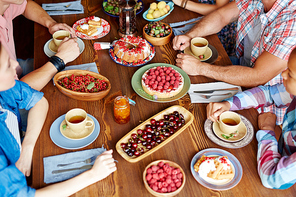 Various yummy food on table and group of friends having dinner