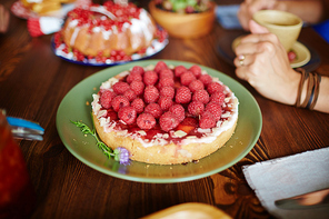 Tasty cake decorated with fresh raspberries on plate