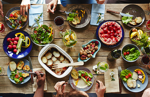 Several people eating dinner by table