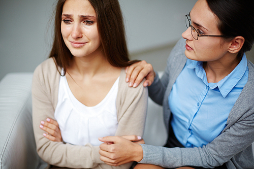 Psychologist supporting depressed girl during session