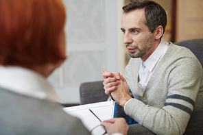 Worried man sharing his trouble with psychologist