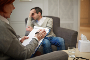 Experienced psychologist writing down her patient story