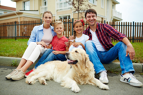 Caucasian family and their pet having rest not far from new house