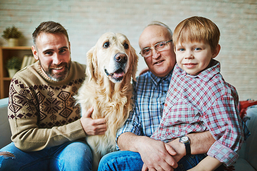 Portrait of senior man, his son, grandson and dog
