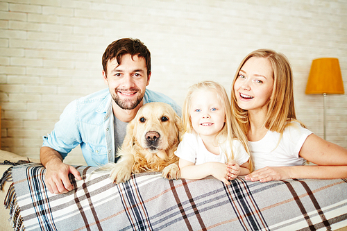 Happy young couple, their daughter and dog enjoying weekend