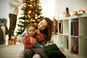 Mother and daughter sewing decorative toy to hang on xmas tree