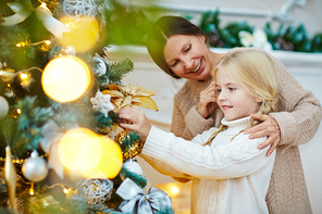 Girl and her granny preparing firtree for Christmas