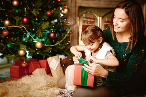 Little girl tying knot on top of gift-box