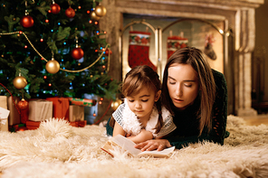 Mother and daughter reading xmas fairy-tales