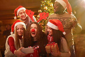 Merry guys and girls making selfie at xmas party